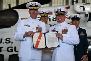 Coast Guard Rear Adm. Bob Little (left), commander of the Coast Guard Arctic District, poses for a photo with Capt. Timothy Williams (second to right), outgoing commanding officer of Air Station Kodiak. (U.S. Coast Guard photo by Petty Officer 3rd Class Rylan Singleton)