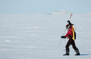 UW graduate student Melinda Webster uses a probe to measure snow depth and verify NASA airborne data. She is walking on sea ice near Barrow, Alaska in March 2012. Her backpack holds electronics that power the probe and record the data. Image-Chris Linder / Univ. of Washington