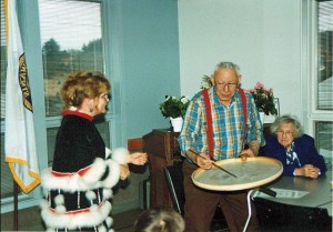 DeeDee Chya dancing, Old Harbor Elder Larry Matfay drumming. Martha Matfay seated in background. Image-Mike Rostad collection