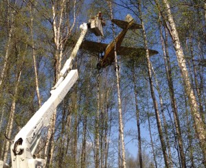 MEA lineman works to free pilot from small plane crashed into trees near Meadow Lakes in May 2014. Image-MEA