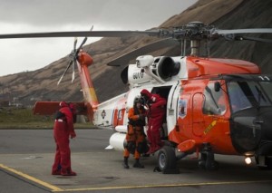 Petty Officer 1st Class Jon Emerson assists three men out of a Coast Guard Air Station Kodiak MH-60 Jayhawk helicopter after a search and rescue mission 57 miles from Kodiak.(U.S. Coast Guard photo by Petty Officer 2nd Class Diana Honings)