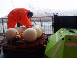 NOAA Fisheries scientist Robert Levine prepares the upward-facing sonar unit for deployment in Shelikof Straits in February of 2015. Image-NOAA