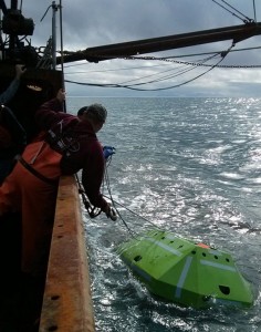 To retrieve the sonar unit, scientists sent an acoustic signal to the unit, causing it to detach from it's mooring and float to the surface. In this photo, crew aboard a chartered fishing vessel retrieve the unit after it surfaced. Credit: NOAA