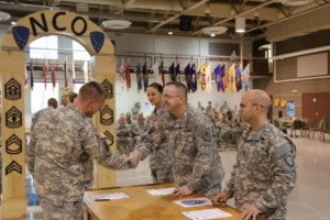 Command Sgt. Maj. Hildreth (second from right) shakes the hands of Sergeants attending the Non-Commissioned Officer’s Professional Workshop as they were inducted into the NCO Corps during a ceremony held at the Alaska National Guard armory on Joint Base Elmendorf-Richardson