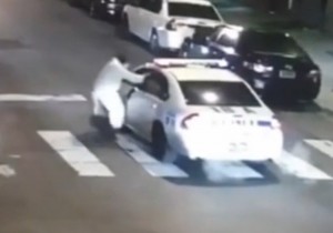 Gunman shown at the patrol car after firing as he approached. Image-Surveillance video