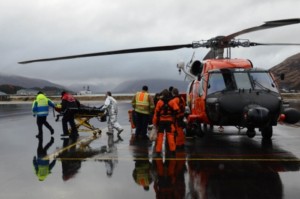 An injured crewmember from the 728-foot cargo ship Cemtex Venture is transferred to awaiting emergency medical services personnel at Air Station Kodiak. (U.S. Coast Guard photo by Petty Officer 1st Class Kelly Parker)