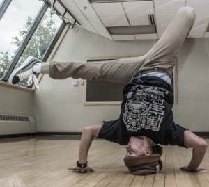 Alaska National Guardsman Sgt. Brianna McMillen, a UH-60 Black Hawk helicopter crew chief with 1st Battalion, 207th Aviation Regiment, breakdances at the Fairview Recreation Center in Anchorage, Alaska, July 23, 2015. (Photo courtesy of Darel Carey, LiHai Art)