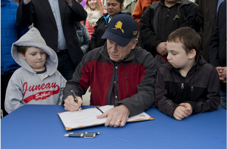 Alaska's Governor Walker signing  HB 128 into law at the Juneau Maritime Festival on Sunday. Image-State of Alaska