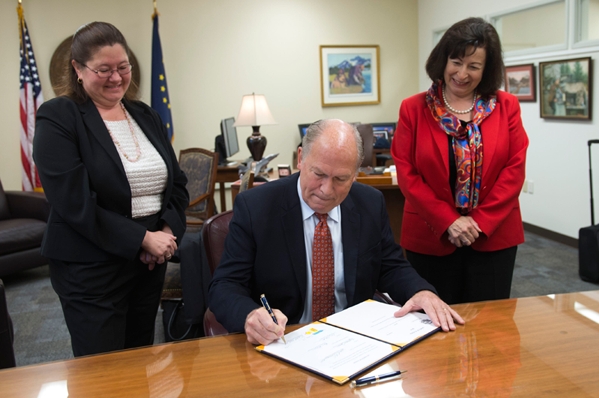Governor Walker signing House Bill 234 while Representative Vazquez and a staffer look on. Image-State of Alaska