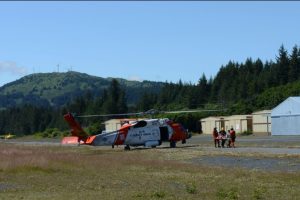 The crew of an MH-60 Jayhawk transfers the victim of the Chiniak Highway ATVV rollover to EMS at the Lilly Lake Seaplane Base in Kodiak. Image-Petty Officer 1st Class Kelly Parker | USCG