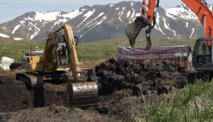 Two excavators dig up contaminated soil and old, rusted diesel drums June 20 at Attu Island, the western-most island in the Aleutian chain. (Photo by Dena O'Dell, USACE-Alaska District Public Affairs)