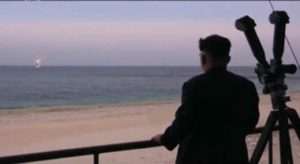 North Korea's Kim Jong Un observing launch of ballistic missile from submarine.