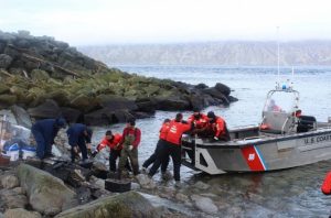 Crewmembers from the Coast Guard Cutter SPAR work alongside residents from the island of Little Diomede to load electronic waste onto SPAR's small boat to be properly disposed of on the mainland Aug. 25, 2016. Image-Petty Officer 1st Class Austen Shannon/USCG