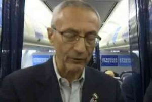 Clinton Campaign chief, John Podesta speaking to reporters on the campaign plane about latest round of email releases. Image-Screengrab