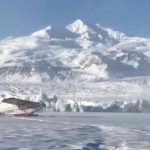 The Piper rests on a frozen lake after a crash-landing in deep snow . Image-USCG