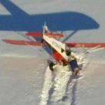 The pilot assesses the damage to a single-engine Super Cub airplane on Hallo Glacier Lake near Shelikof Strait. Image-USCG