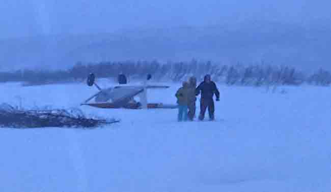 Three people walk away after their Cessna 180 crashed near a ridgeline landing strip in the vicinity of the Chakachatna River in the Kenai Peninsula Borough. Photo by Petty Officer 1st Class William Colclough