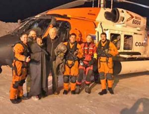 Three survivors aboard a downed Cessna 180 take a photo with the Coast Guard Air Station Kodiak MH-60T Jayhawk crew who rescued them. Photo by Petty Officer 1st Class William Colclough/USCG