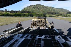 Tech. Sgt. Tom Hough (right), a loadmaster assigned to the 249th Airlift Squadron with the Alaska Air National Guard, signals to raise a pallet of equipment and supplies to load onboard a C-17 Globemaster III cargo aircraft at Coast Guard Air Station Kodiak. U.S. Coast Guard photo by Petty Officer 1st Class Bill Colclough.