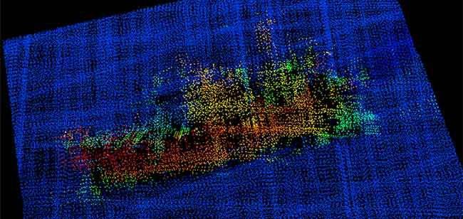A 3-D image from NOAA Ship Fairweather multi-beam sonar. The profile of the F/V Destination is clearly visible, including the bulbous bow to the right, the forward house and mast, equipment (likely crab pots) stacked amidships, the deck crane aft, and the skeg and rudder. (NOAA)