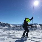 A snowmachiner in Thompson Pass measures snow depth with an avalanche probe. Image-Gabe Wolken