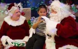Santa and Mrs. Claus meet young St. Michael boy during this year's Op Santa to the  village. Image-2nd Lt. Marisa Lindsay