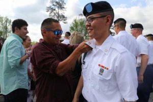 Pvt. Donald Lincoln, an Alaska Army National Guard Soldier from Nome, is bestowed the blue infantry cord by his brother, Richard Scott, during the Turning Blue Ceremony held on Kennal Field at Fort Benning, Georgia, April 19, 2018. (U.S. Army National Guard photo by 2nd Lt. Marisa Lindsay/released)