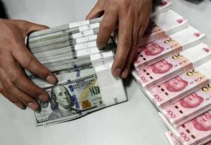 A clerk counts Chinese yuan and U.S. dollar banknotes at a branch of Bank of China