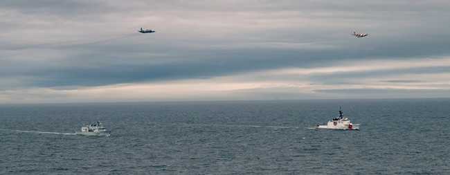 U.S. Coast Guard Cutter Waesche (WMSL-751) and Royal Canadian Navy His Majesty’s Canadian Ship Regina, sail alongside each other as a USCG Air Station Kodiak HC-130 and Royal Canadian Air Force CP-140 Aurora fly overhead during Operation LATITUDE in the Bering Sea. (Courtesy photo by Canadian Armed Forces Master Corporal William Gosse)
