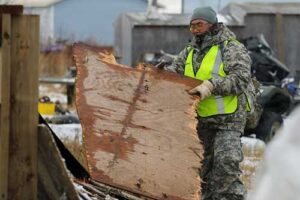 Alaska State Defense Force Sgt. Timothy Henry, assigned to Task Force Bethel, cleans up debris at Tuntutuliak during Oct. 25, 2025, post-storm recovery efforts for Operation Halong Response. Along Alaska Organized Militia members of the Alaska Army and Air National Guard, as well as the Alaska Naval Militia, Alaska State Defense Force volunteers were a crucial part of the Typhoon Halong response. (Alaska National Guard photo by Capt. Balinda O’Neal)