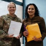 JOINT BASE ELMENDORF-RICHARDSON, Alaska - Alaska Army National Guard Capt. Balinda O’Neal, left, 134th Public Affairs Detachment commander, assigned to Kosovo Force (KFOR) Regional Command-East, presents letters to Festa Shabani, Future School program director, for students to participate in a pen pal exchange with youth in Alaska. (U.S. Army photo by Staff Sgt. Marc Marmeto)