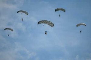 Paratroopers from the U.S. Army and Air Force execute a military free fall into a drop zone at La Fiere, France, June 07, 2026. D-Day 82 commemorates the courage and sacrifice of Allied forces who fought for freedom, reminding us of the enduring strength of alliances and shared responsibility. (U.S. Air Force photo by Tech. Sgt. Shawn White)