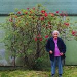 Photo: Alexandra (Sacha) Smith standing in front of a Pacific Red Elder bush in fruit, ca. 1991. Photo by Priscilla Russell, KANA collection.