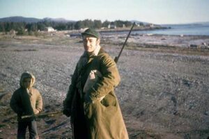 Photo: Hunter on the beach in Afognak village, ca. 1960. Chadwick Collection.