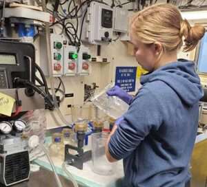 A scientist filters water samples in the R/V Bell M. Shimada Chemistry Lab. Credit: UW APL/Phil LaMothe.
