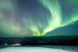 Photo by Bryan Whitten. The aurora lights the sky above Poker Flat Research Range north of Fairbanks in late January 2025.