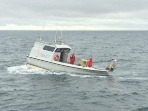 A Coast Guard Station Valdez boatcrew responds to a 30-foot fishing vessel taking on water near Valdez, Alaska, July 27, 2015. The fishing vessel Fishing Time had a four-inch crack in the hull that the Station Valdez boatcrew assisted with repairing before escorting the two boaters to Cordova. (U.S. Coast Guard photo)