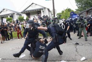 Police scuffle with a demonstrator as they try to apprehend him during a rally in Baton Rouge, Louisiana July 10th. Image-Reuters/Shannon Stapleton