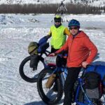 Photo by Ned Rozell Forest Wagner, left, and Ned Rozell pause in front of the tripod on the ice of the Tanana River at the town of Nenana. When the river ice breaks up and the tripod pulls a cable attached to shore, the person who guessed the time will win the Nenana Ice Classic.