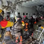 Guardian Angels of 212th Rescue Squadron stand by to jump from a 211th Rescue Squadron HC-130J Combat King II during an Aug. 8, 2025, rescue mission in the North Pacific Ocean. The Guardian Angels carried the necessary equipment to treat a critically ill patient aboard a South Korean fishing vessel. (Courtesy photo)