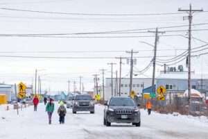 UAF photo by Eric Engman
Above a street in Kotzebue, electric distribution lines carry wind and solar energy to residents and businesses. Future expansions of renewables can be modeled in MiGRIDS Lite.