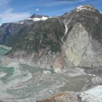 Photo by Cyrus Read/U.S. Geological Survey The photograph shows the Aug. 10, 2025, landslide, glacier terminus and Tracy Arm as viewed from across the fjord during a U.S. Geological Survey flight on Aug. 13. Note the trimline along the far side of the fjord, caused by the tsunami stripping the walls of vegetation.