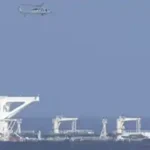 A US military helicopter flies over the oil tanker Centuries in the southern Caribbean Sea on December 20, 2025. (Photo by US Department of Homeland Security)