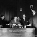 Alfred Shoup, Conrad Freeding, W.W. Shorthill watch Governor Walter E. Clark sign the sufferage bill. Image-Public Domain