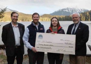 From left: Executive Director of Southeast Conference Robert Venables, VP and Director of Energy Services Alec Mesdag, current scholarship recipient Marina Ogai and Chancellor Rick Caulfield stand by the Auke Lake on the main University of Alaska Southeast campus Friday, Dec 13, 2019 in Juneau, Alaska. (Photo credit: Seanna O’Sullivan)