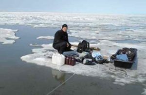 Researcher James McClelland sampling water during ice break-up in Kaktovik Lagoon, Alaska.  Credit: Kenneth Dunton