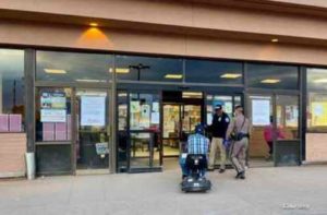 Navajo official and police officer assisting an elderly shopper for "Operation First of the Month" to keep them safe during COVID-19 outbreak.