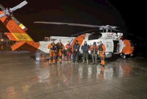 An MH-60 Jayhawk helicopter crew from Air Station Sitka, share a moment at the Juneau Airport with three boaters they rescued about an hour earlier. (U.S. Coast Guard photo by Coast Guard Air Station Sitka)