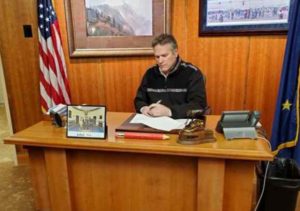  Governor Dunleavy signs a Disaster Declaration in his Juneau office in 2020.
