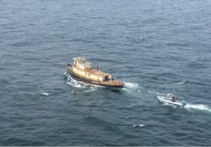 The derelict tugboat Lumberman is towed by a crew aboard the (not pictured) Coast Guard Cutter John McCormick, a 154-foot Sentinel–class vessel, to a position 54 miles west of Cross Sound. U.S. Coast Guard courtesy photo.